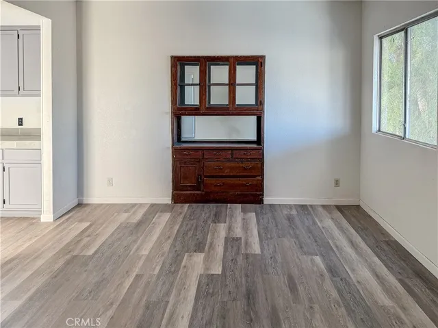 an empty room with wooden floor and window