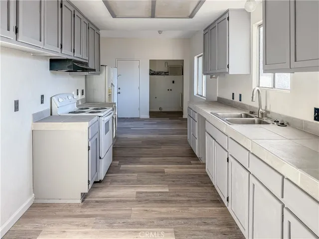 a kitchen with stainless steel appliances granite countertop a sink stove refrigerator and cabinets