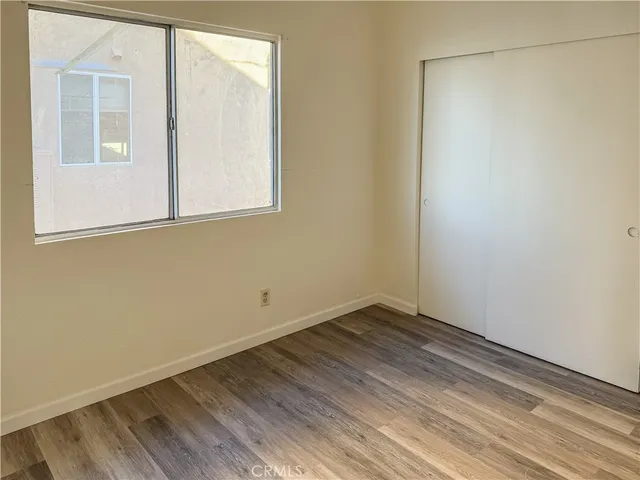 a view of a small space with wooden floor and a window