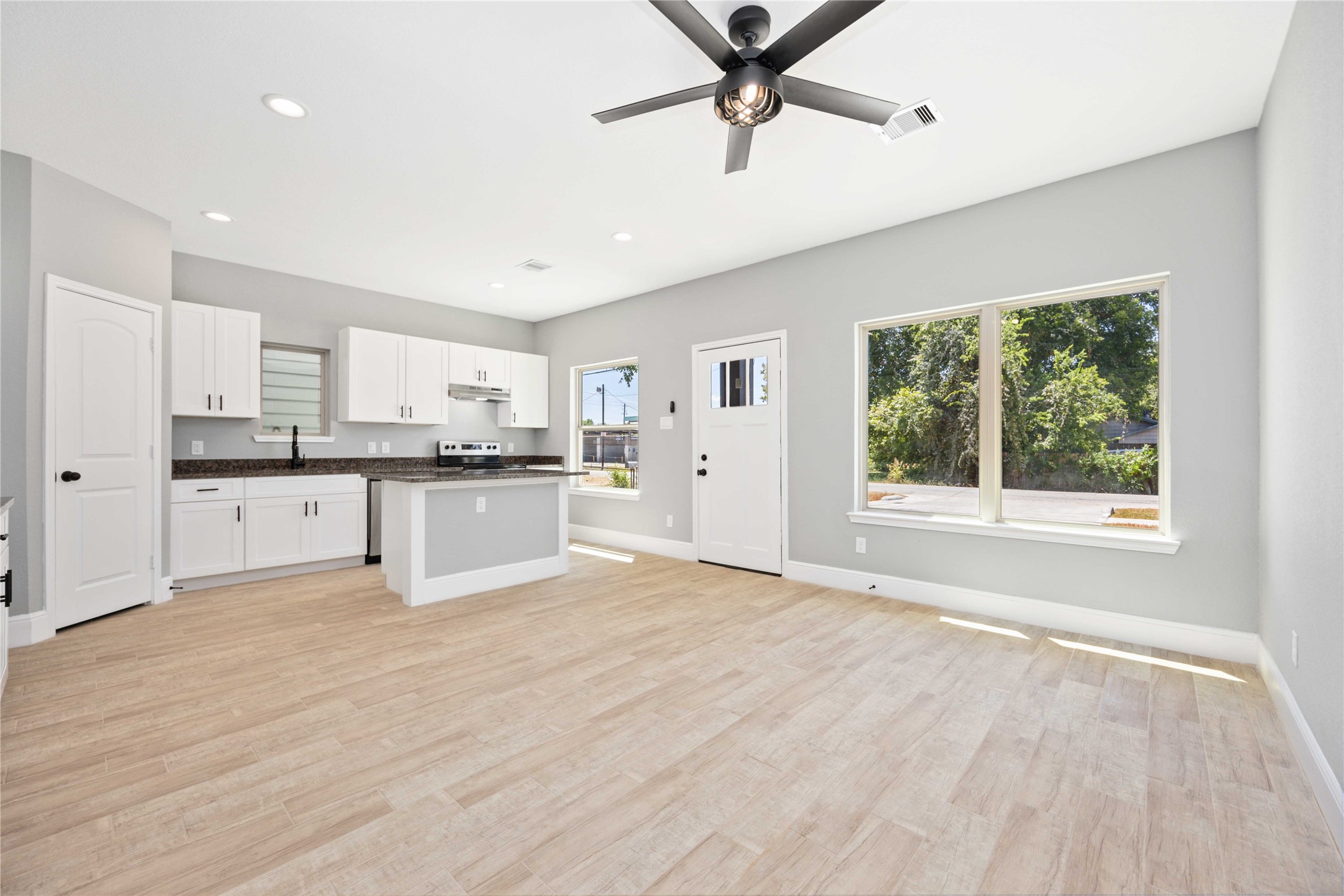 4651 Mallow Street, Unit B Houston, TX 77051 - Photo 12 of 22 a large white kitchen with stainless steel appliances granite countertop a stove a sink dishwasher and a refrigerator with wooden floor