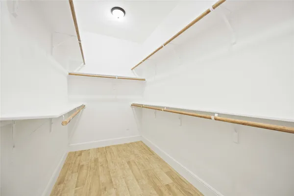 a view of walk in closet with empty racks