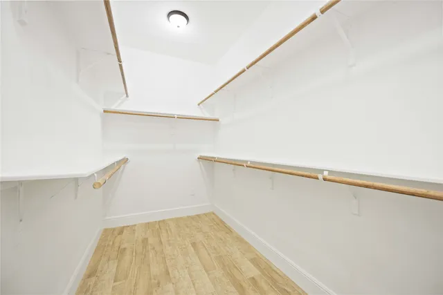 a view of walk in closet with empty racks