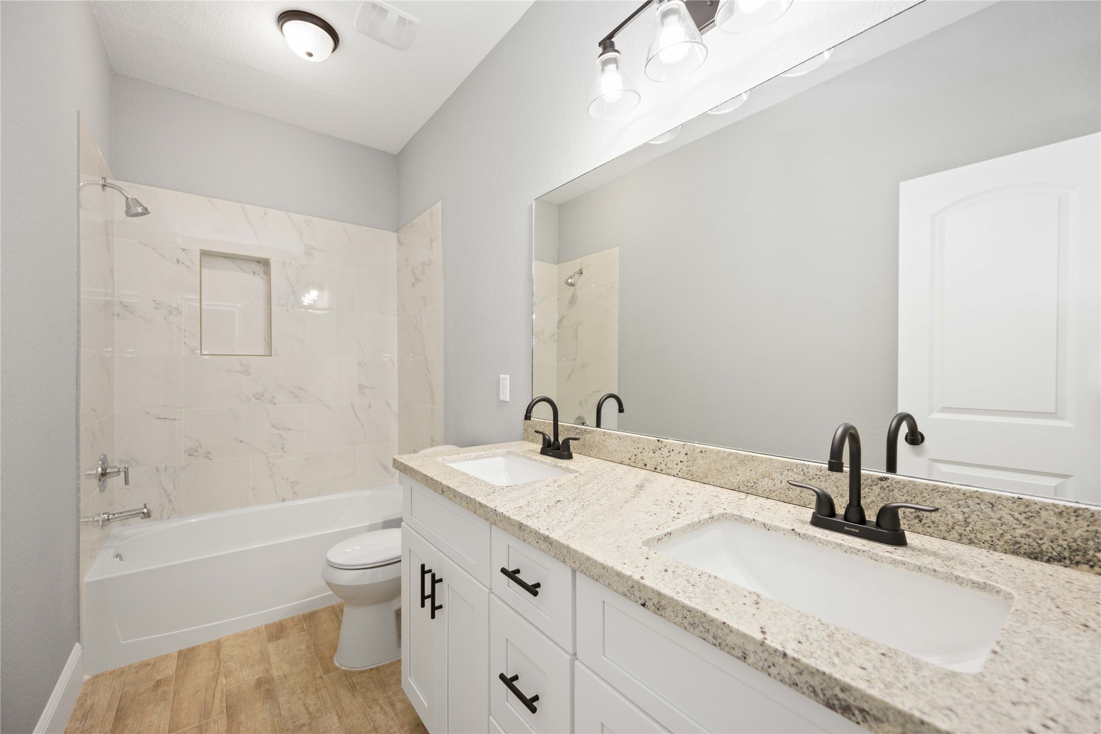 4651 Mallow Street, Unit B Houston, TX 77051 - Photo 17 of 22 a bathroom with a granite countertop sink toilet and shower