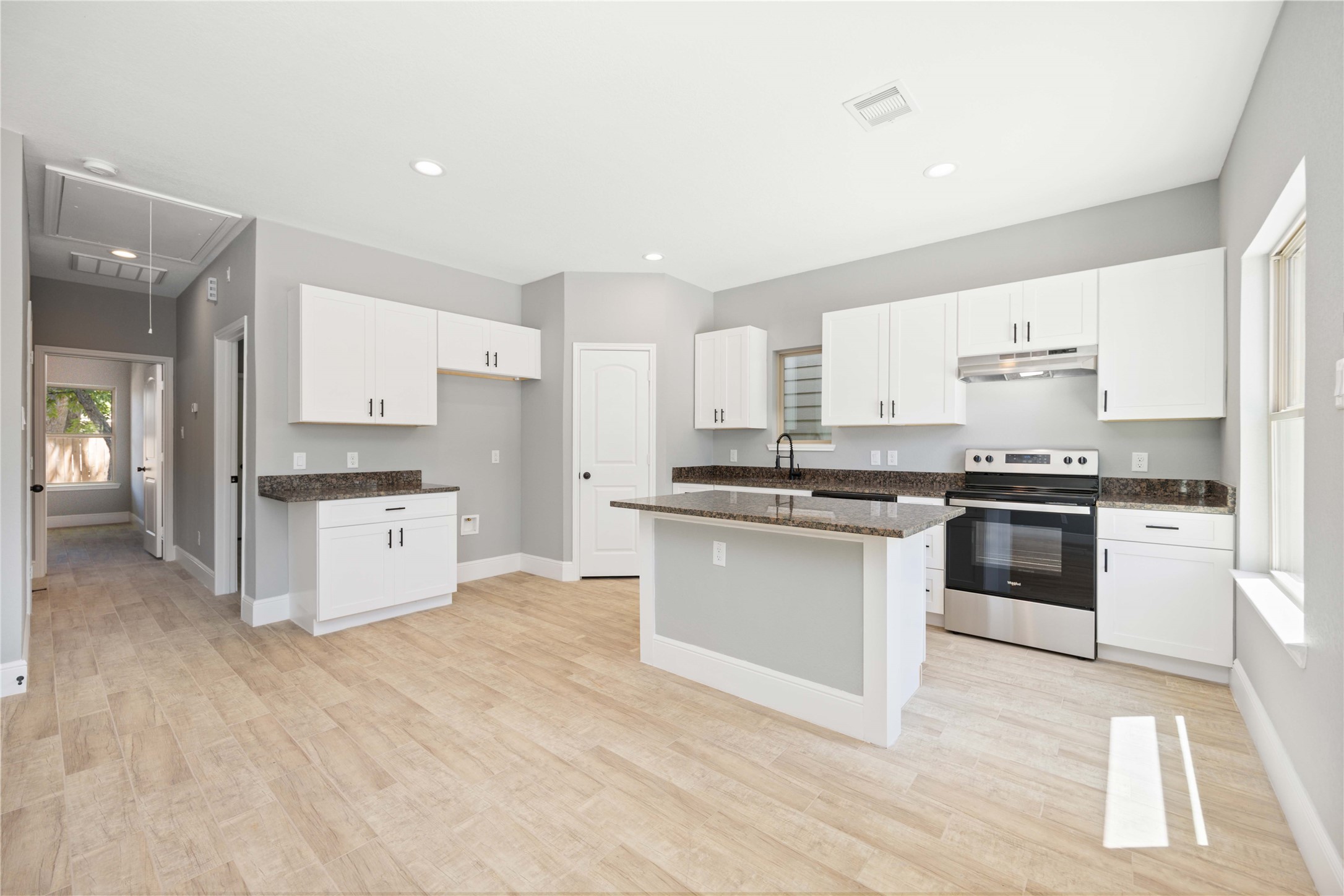 4651 Mallow Street, Unit B Houston, TX 77051 - Photo 6 of 22 a kitchen with granite countertop a stove top oven and cabinets