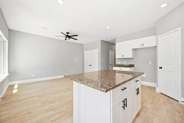 a kitchen with stainless steel appliances granite countertop a sink dishwasher and a refrigerator with wooden floor