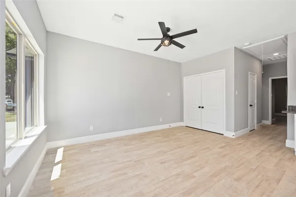 a view of a big room with wooden floor closet and windows