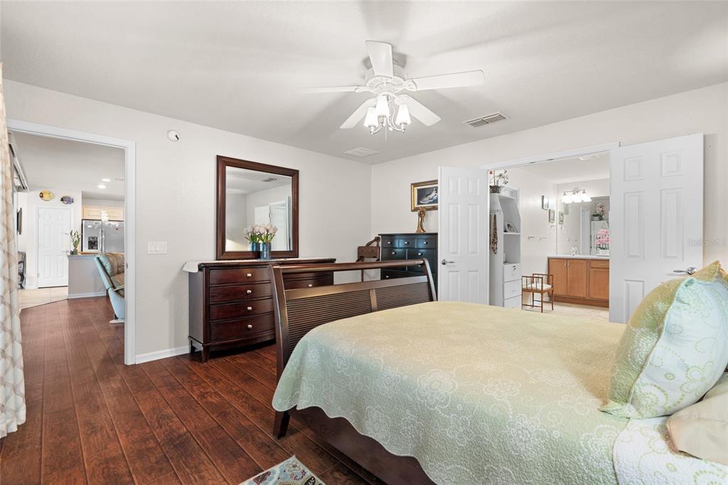 4683 Southwest 40th Place Ocala, FL 34474 - Photo 18 of 43 a large bedroom with wooden floor and furniture