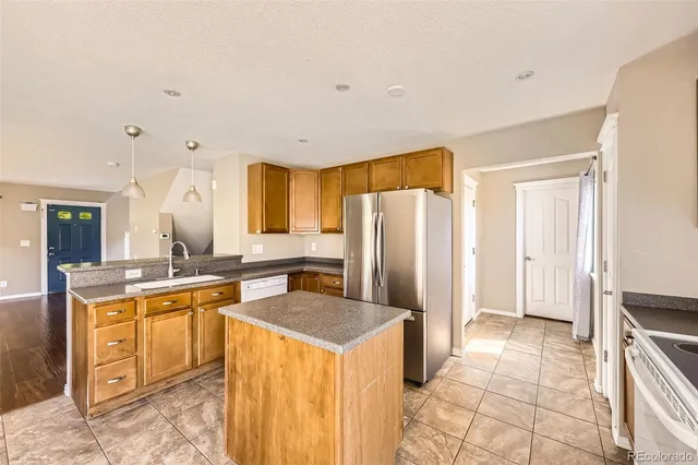 a kitchen with a sink a refrigerator and cabinets
