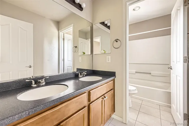 a bathroom with a granite countertop sink and a mirror a vanity