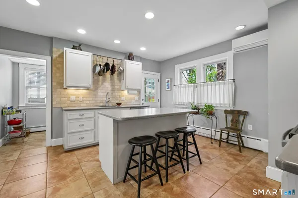 a kitchen with stainless steel appliances kitchen island granite countertop a table and chairs