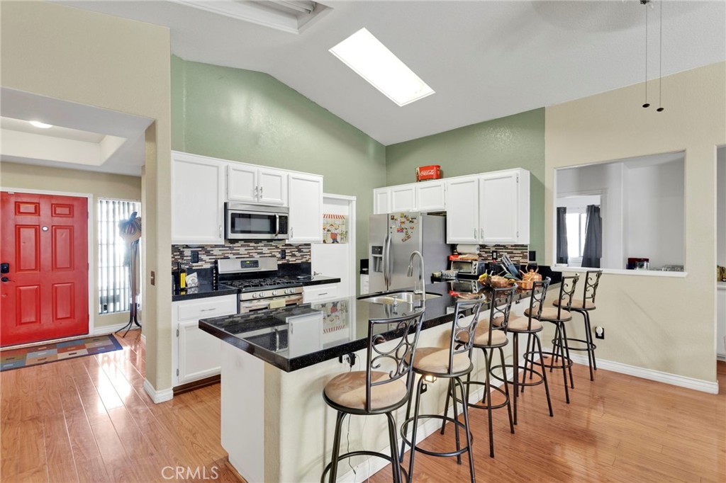 14405 Cedar Street Hesperia, CA 92344 - Photo 2 of 48 a kitchen with stainless steel appliances a table chairs refrigerator and microwave