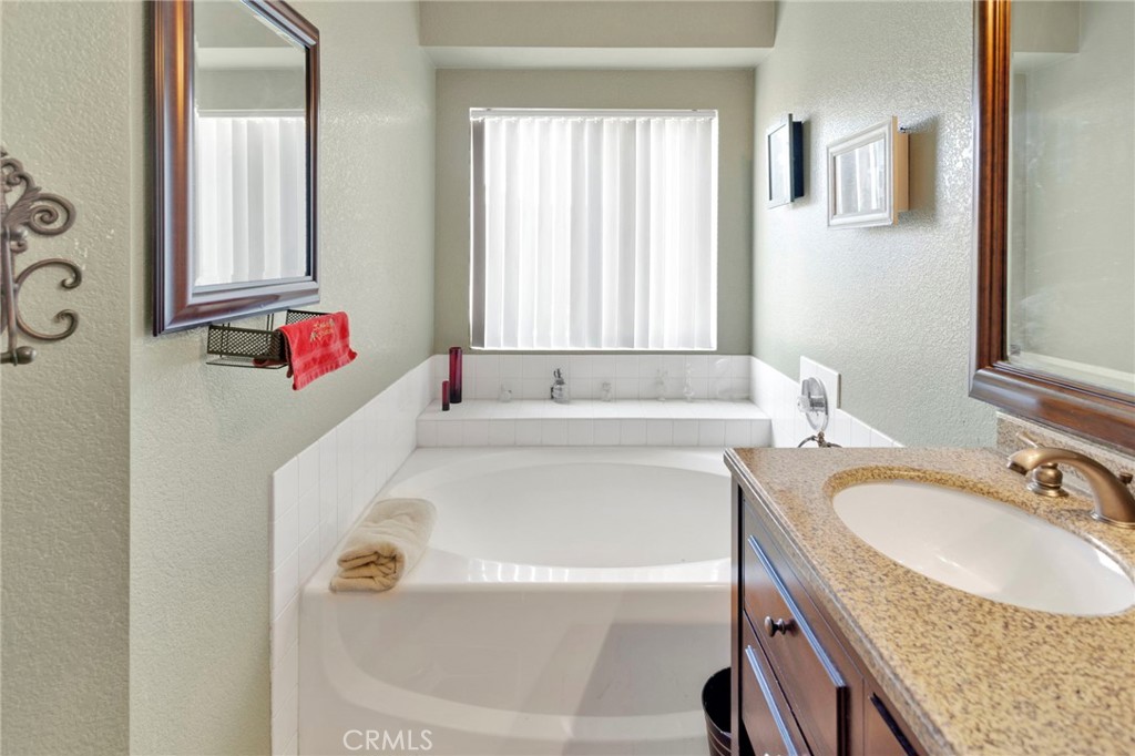 14405 Cedar Street Hesperia, CA 92344 - Photo 21 of 48 a bathroom with a tub sink and mirror