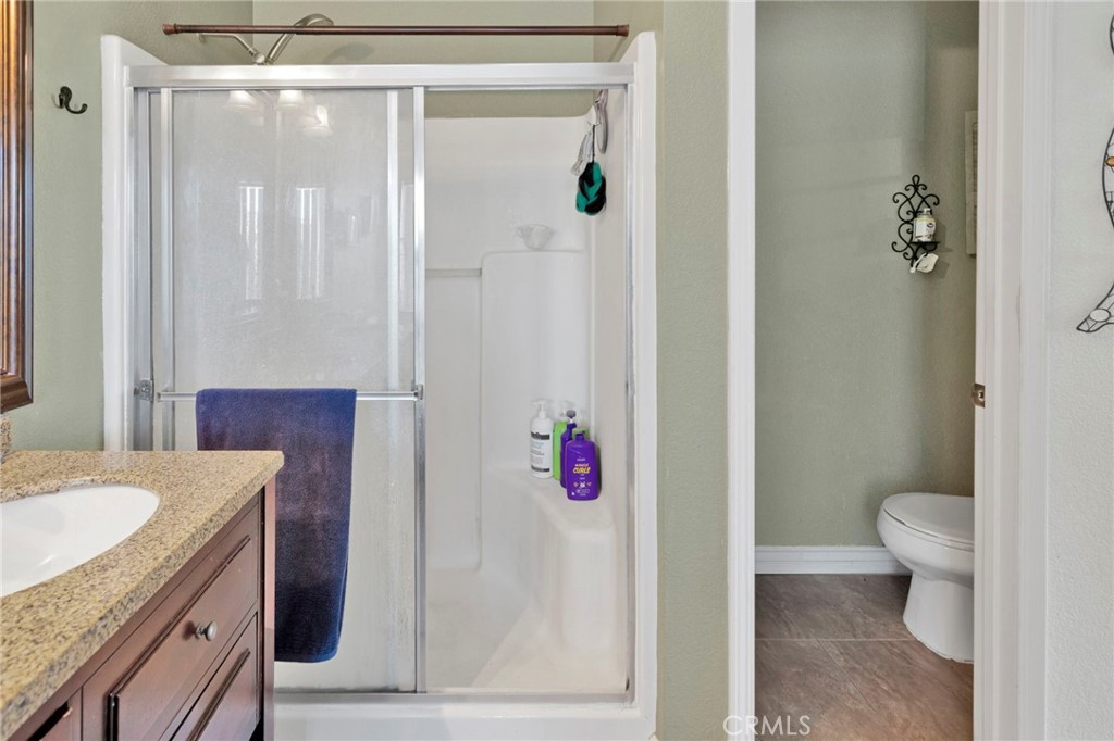 14405 Cedar Street Hesperia, CA 92344 - Photo 22 of 48 a bathroom with a granite countertop sink a toilet and shower