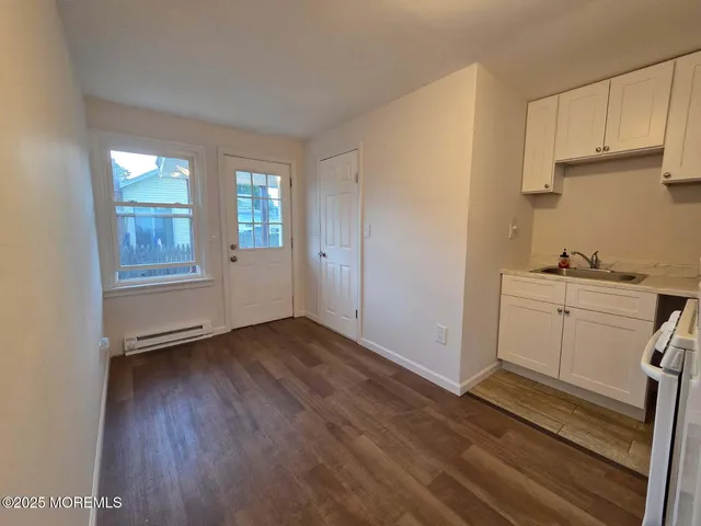 a view of a kitchen with wooden floor and electronic appliances