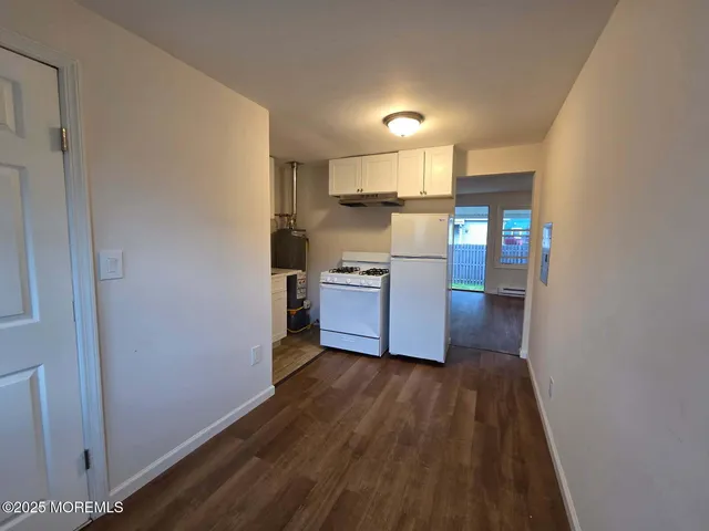 a kitchen with wooden floors and stainless steel appliances