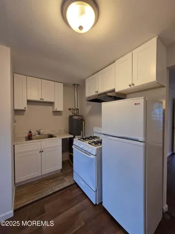 a kitchen with cabinets a refrigerator and a stove