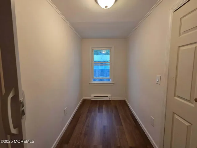 a view of small space with wooden floor and a window
