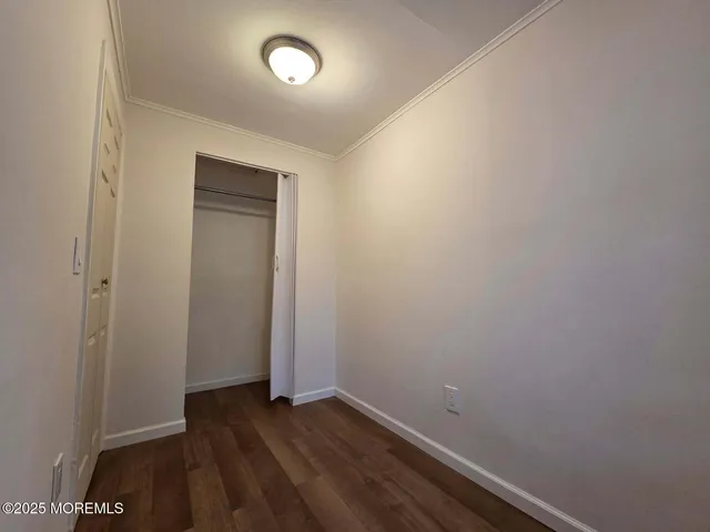 an empty room with wooden floor and closet