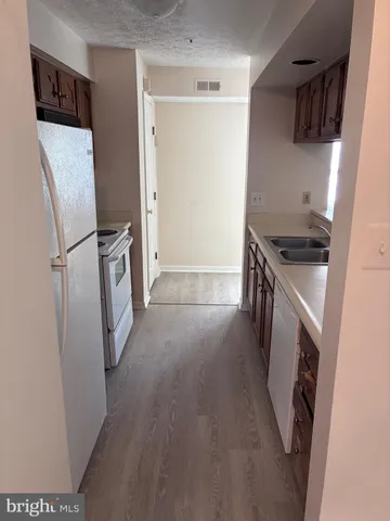 a kitchen with a refrigerator sink stove and cabinets