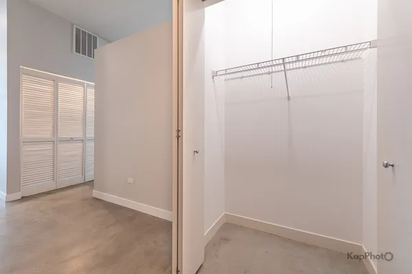 an empty room with windows and closet