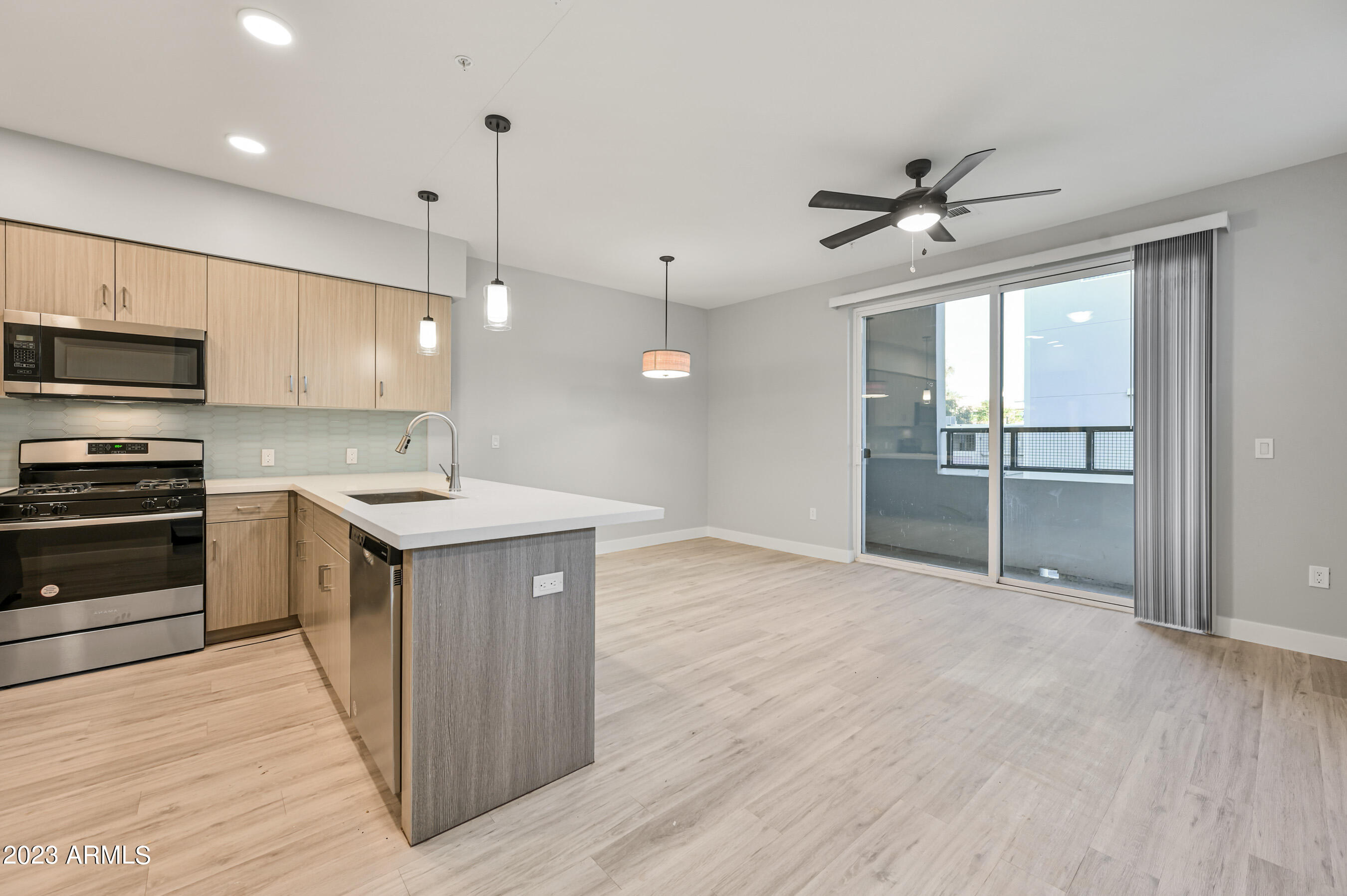 1023 West 5th Street, Unit 1006 Tempe, AZ 85281 - Photo 3 of 35 a kitchen with kitchen island a sink appliances and cabinets