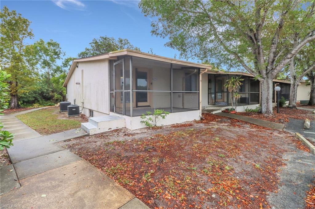 5214 Treetops Drive, Unit I Naples, FL 34113 - Photo 1 of 18 a front view of a house with a yard and garage