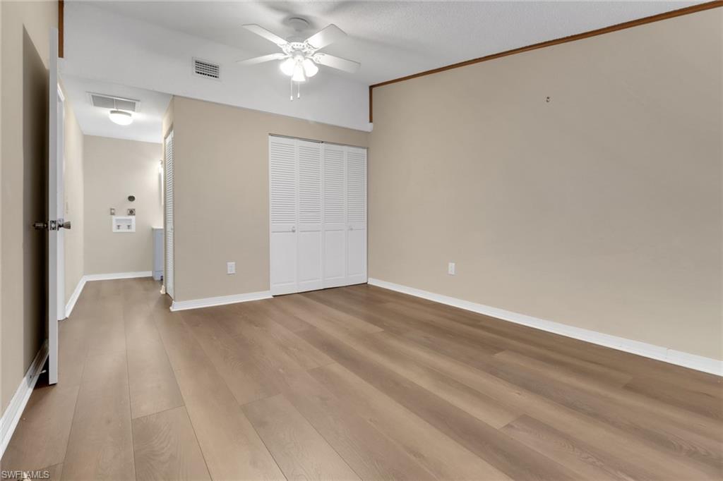 5214 Treetops Drive, Unit I Naples, FL 34113 - Photo 11 of 18 wooden floor in an empty room with a window