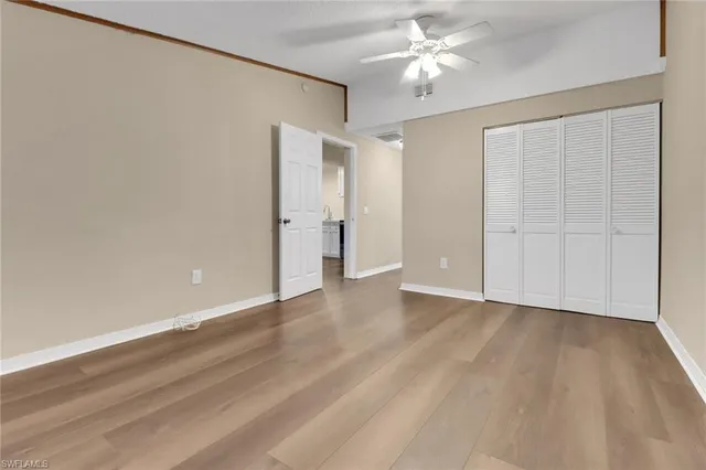 wooden floor in an empty room with a ceiling fan