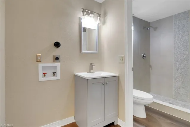 a bathroom with a sink a toilet and shower