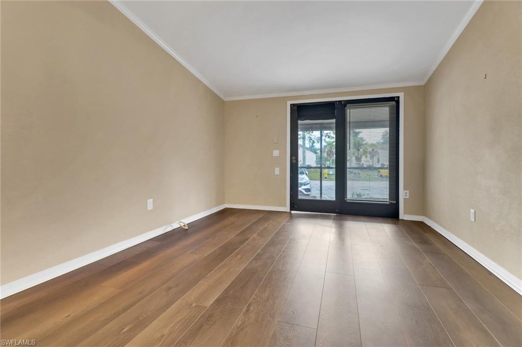 5214 Treetops Drive, Unit I Naples, FL 34113 - Photo 3 of 18 a view of an empty room with wooden floor and a window