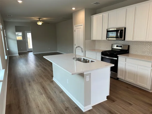 a kitchen with a sink a microwave a stove and refrigerator