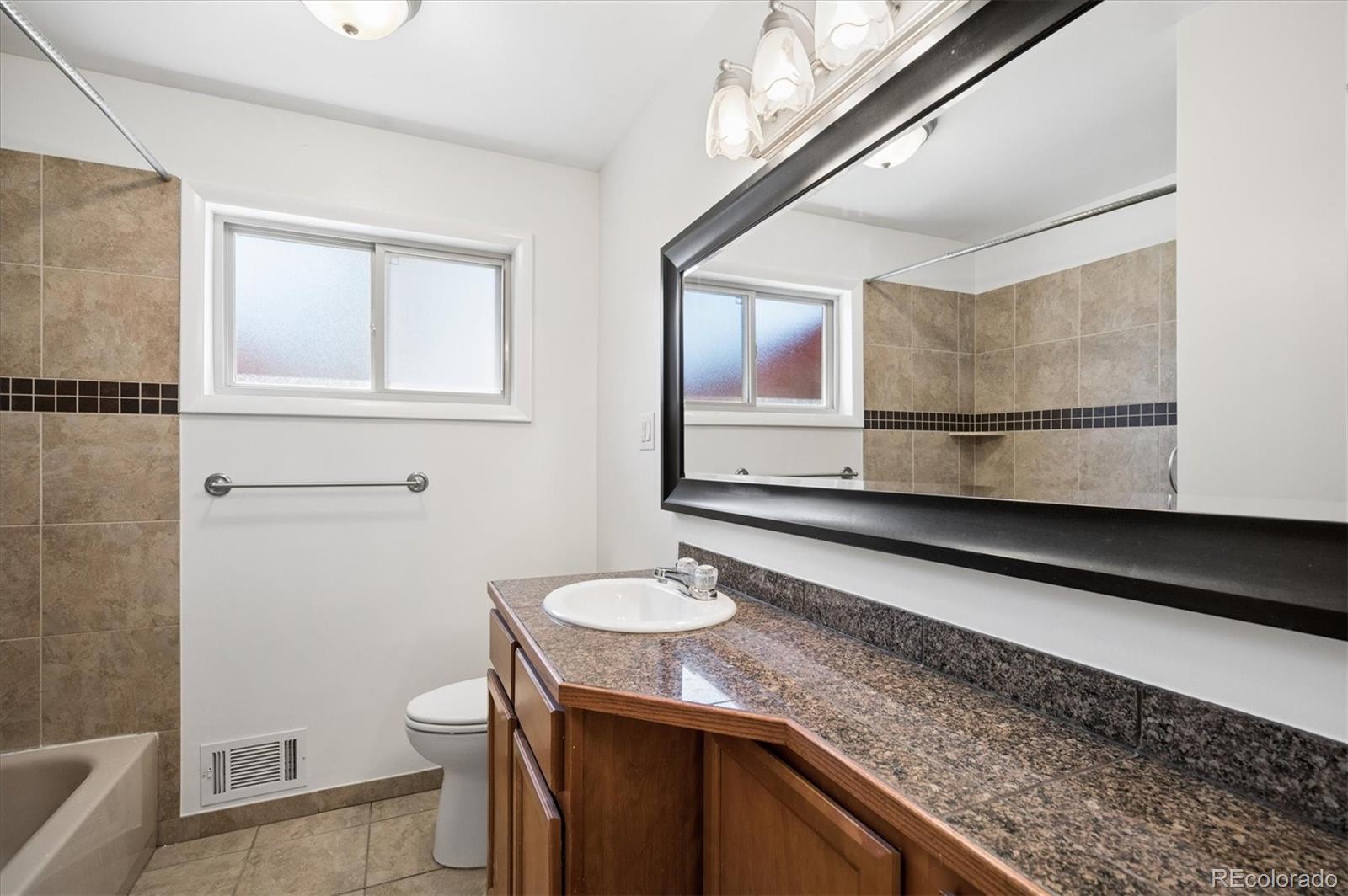 6640 South Williams Circle West Centennial, CO 80121 - Photo 14 of 23 a bathroom with a granite countertop sink a toilet and a mirror