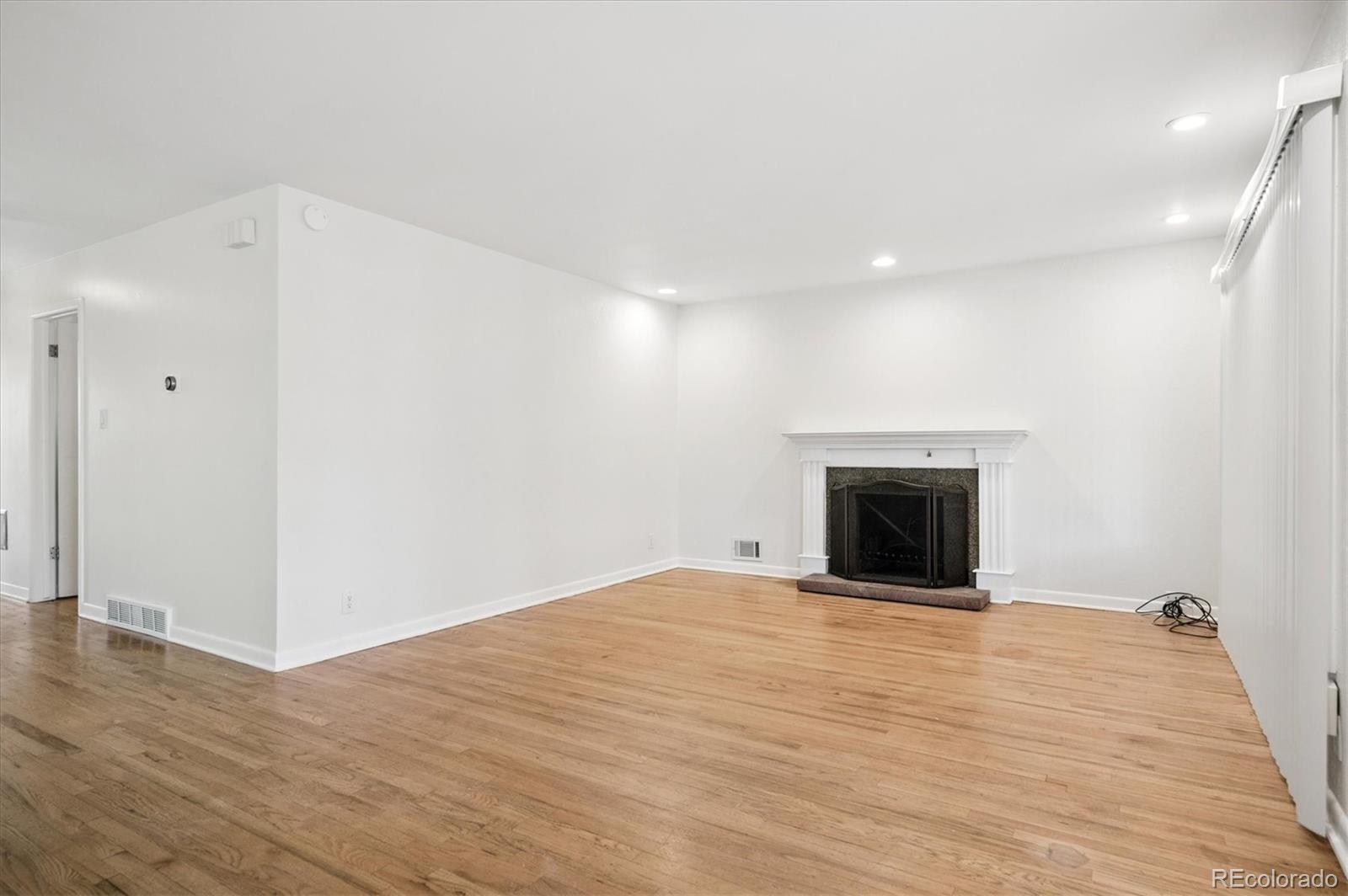 6640 South Williams Circle West Centennial, CO 80121 - Photo 3 of 23 a view of an empty room with wooden floor and a fireplace