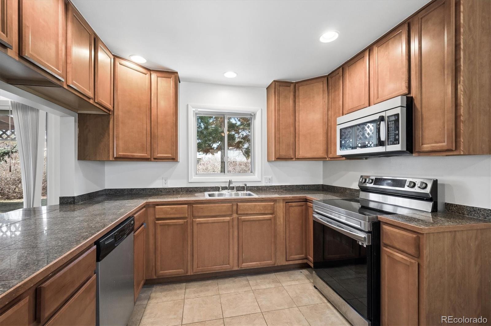 6640 South Williams Circle West Centennial, CO 80121 - Photo 6 of 23 a kitchen with stainless steel appliances granite countertop wooden cabinets stove a sink and dishwasher