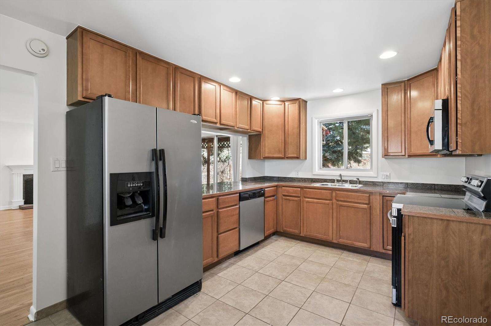 6640 South Williams Circle West Centennial, CO 80121 - Photo 7 of 23 a kitchen with granite countertop stainless steel appliances a refrigerator sink and microwave