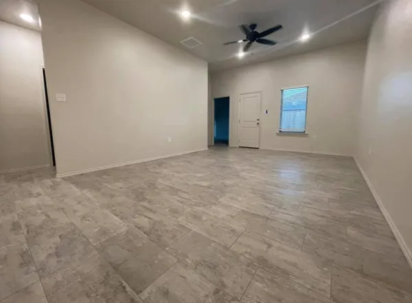 an empty room with an entryway and fan