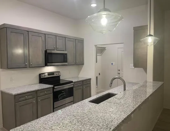 a kitchen with stainless steel appliances granite countertop a sink refrigerator and microwave