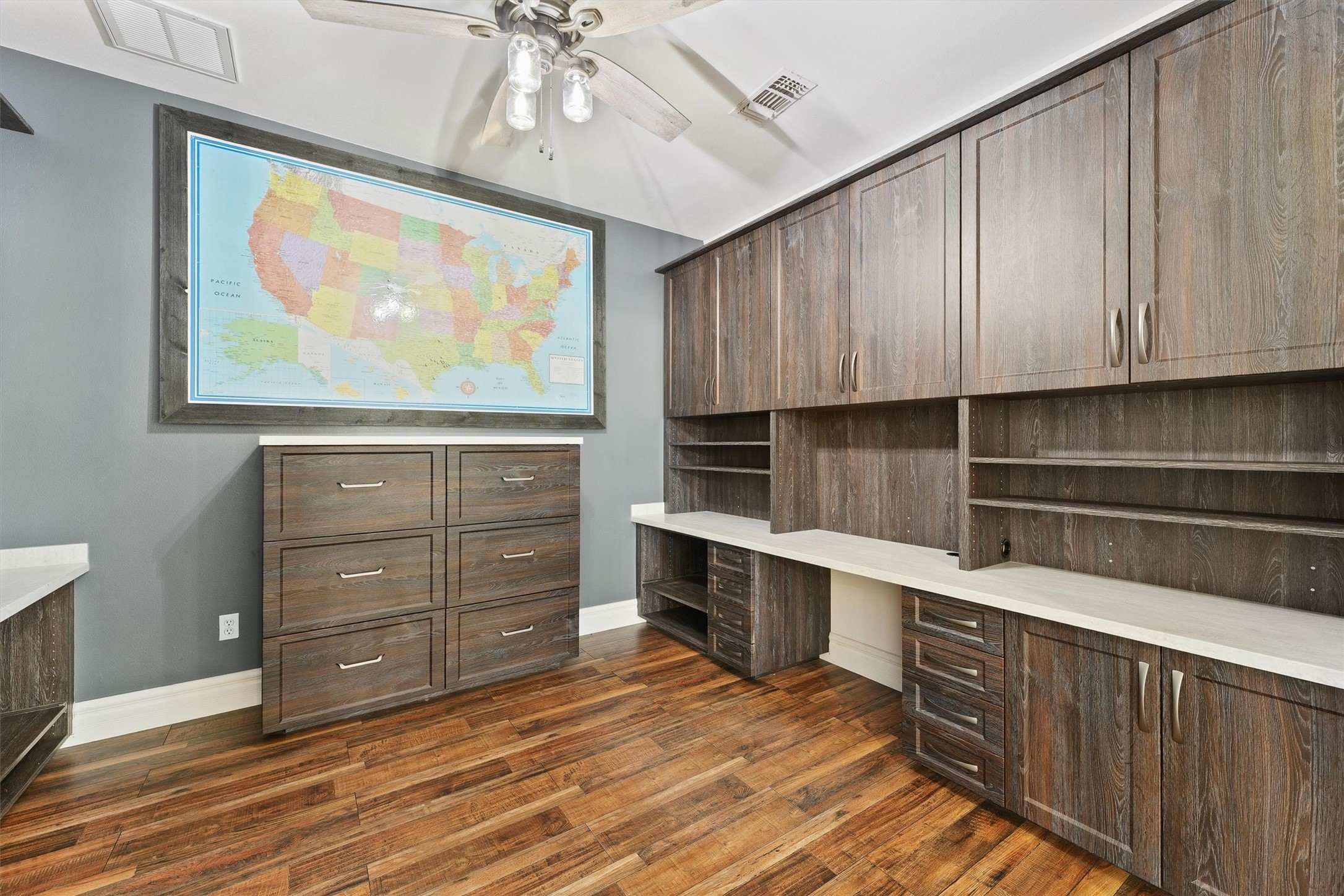 43919 Austin Branch Road Hempstead, TX 77445 - Photo 21 of 48 Step into the private study, where custom built-ins meet classic elegance. Framed by French doors and filled with natural light, this versatile space is ideal for focused work or quiet reflection. A large, elegant map artwork serves as a stunning focal point, adding both character and a sense of worldly charm. Whether used as a home office, library, or creative retreat, this space is as functional as it is inspiring.