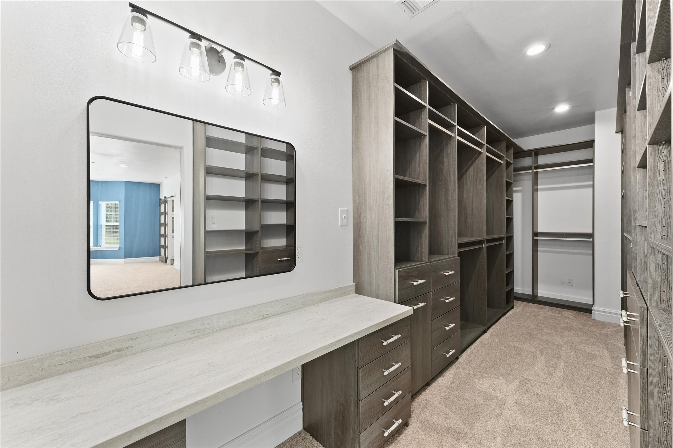 43919 Austin Branch Road Hempstead, TX 77445 - Photo 25 of 48 Step inside this generously sized walk-in closet, thoughtfully designed with custom built-ins that offer abundant storage for everything from shoes to seasonal wardrobe. A dedicated vanity area provides the perfect spot for makeup and daily prep, combining practicality with a touch of luxury. With every detail carefully crafted, this closet is more than just storage—it’s your personal dressing room sanctuary.