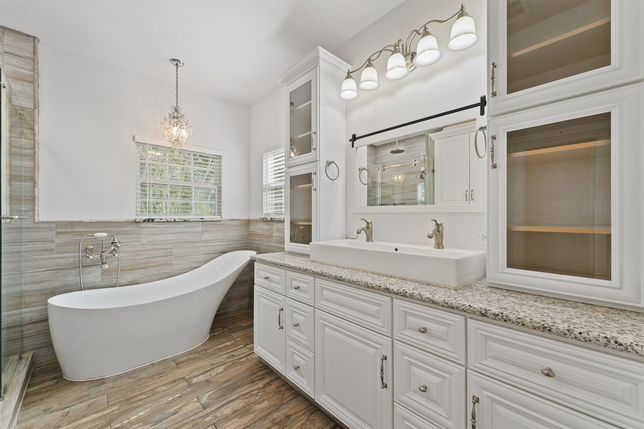 43919 Austin Branch Road Hempstead, TX 77445 - Photo 26 of 48 Indulge in the serene ambiance of the primary bathroom, featuring a stunning soaking tub designed for ultimate relaxation and a spacious walk-in shower with modern fixtures. The beautiful custom vanity, surrounded by ample cabinetry, offers both style and functionality, providing plenty of storage while maintaining a clean, elegant look. This bathroom perfectly combines comfort and sophistication, creating your own peaceful sanctuary.