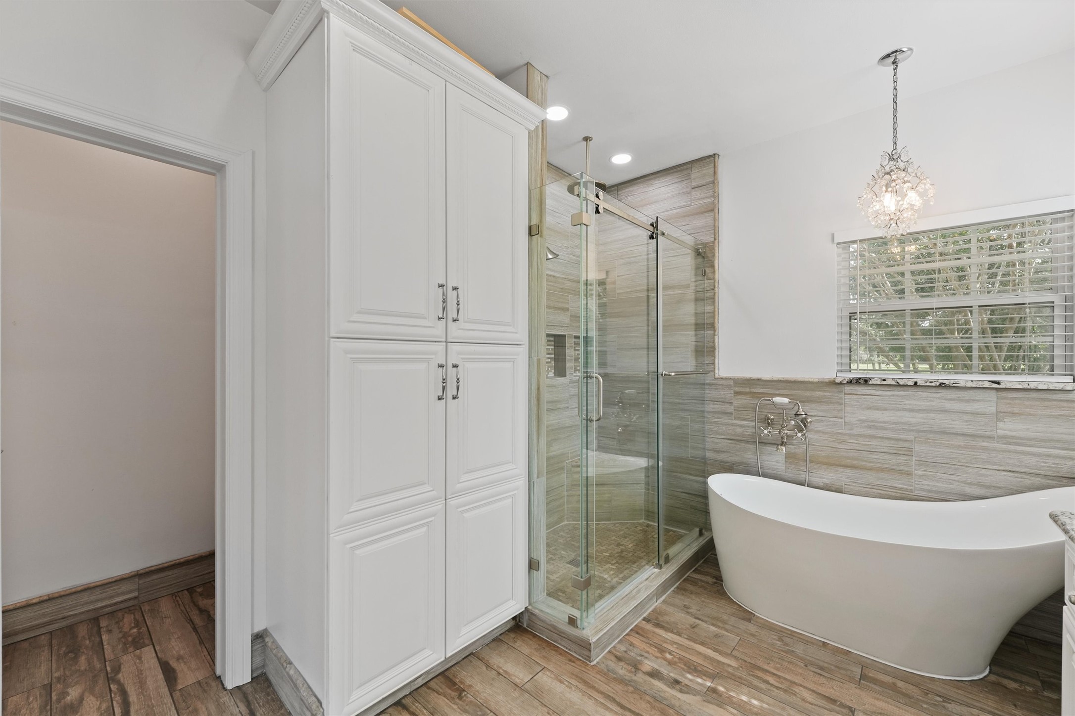 43919 Austin Branch Road Hempstead, TX 77445 - Photo 27 of 48 Indulge in the serene ambiance of the primary bathroom, featuring a stunning soaking tub designed for ultimate relaxation and a spacious walk-in shower with modern fixtures. The beautiful custom vanity, surrounded by ample cabinetry, offers both style and functionality, providing plenty of storage while maintaining a clean, elegant look. This bathroom perfectly combines comfort and sophistication, creating your own peaceful sanctuary.