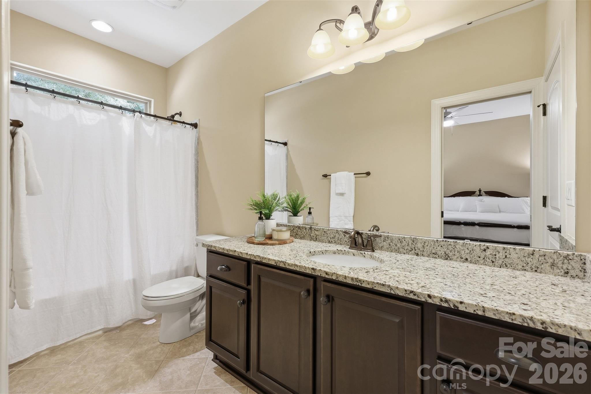 8094 Clems Branch Road Indian Land, SC 29707 - Photo 23 of 38 a bathroom with a granite countertop sink a toilet and a mirror