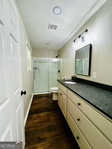 a bathroom with a double vanity sink toilet and shower