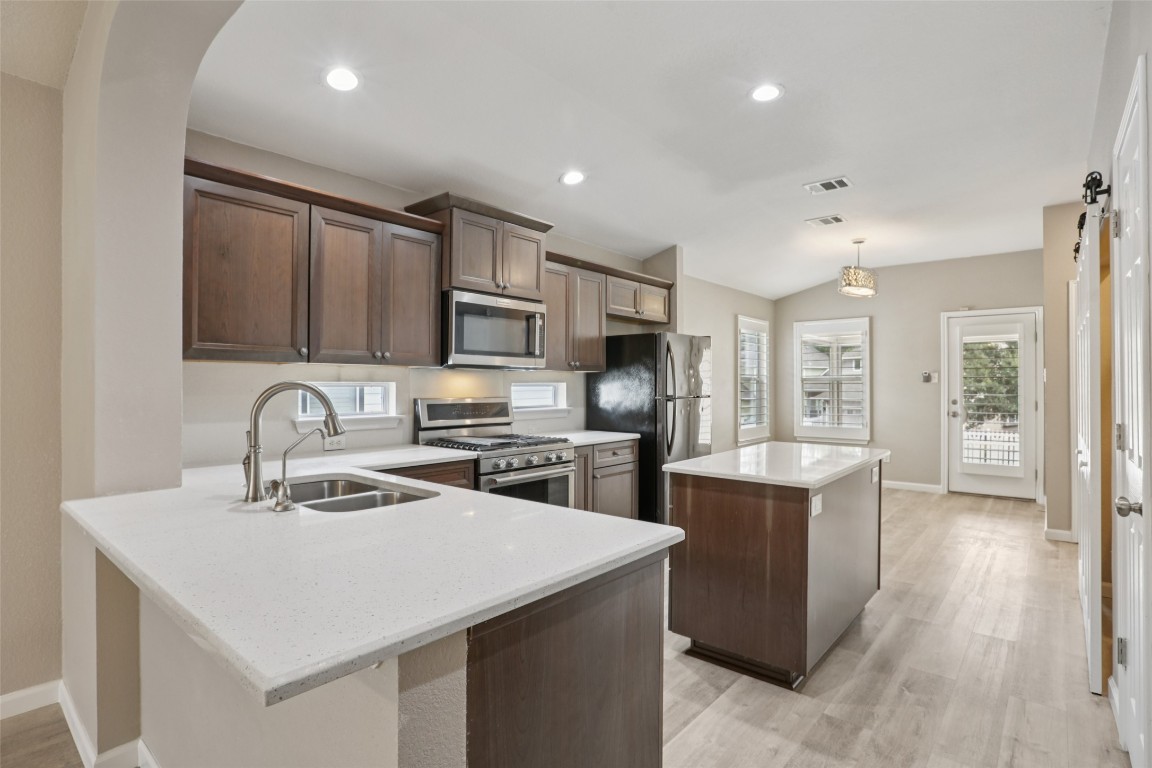 4937 Hartson Kyle, TX 78640 - Photo 13 of 40 a kitchen that has a lot of cabinets in it and wooden floors