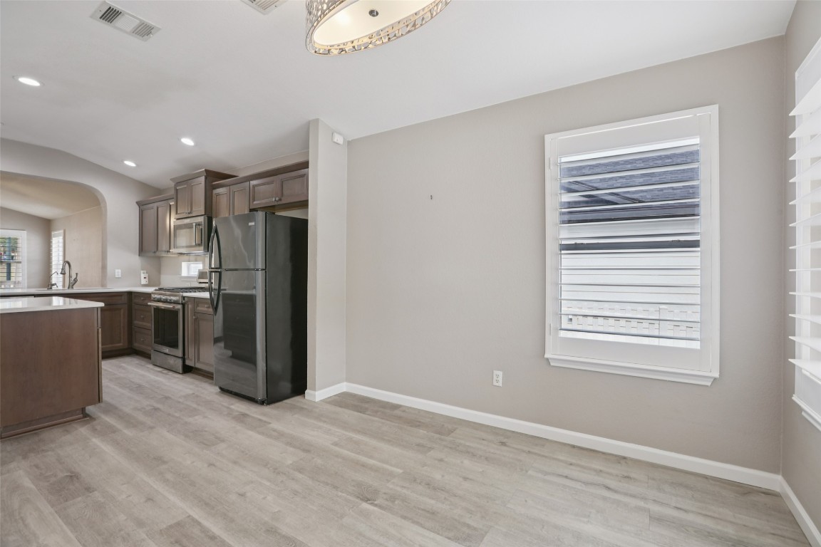 4937 Hartson Kyle, TX 78640 - Photo 19 of 40 a kitchen with stainless steel appliances kitchen island granite countertop a refrigerator and a sink