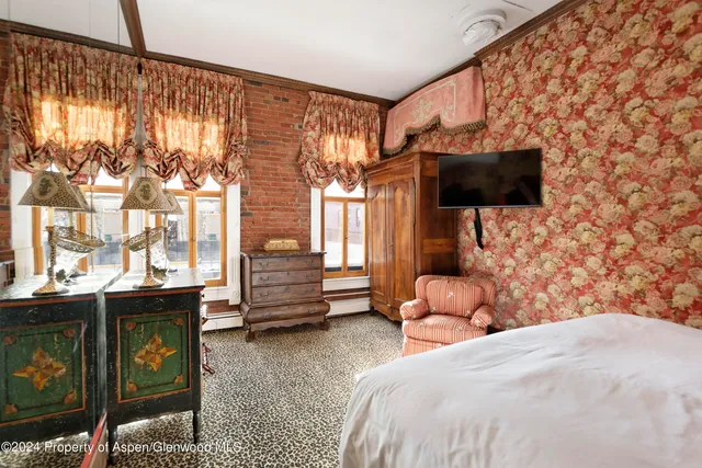 a bedroom with a bed and flat screen tv