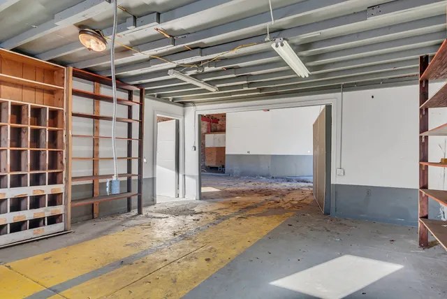 a view of empty room with wooden floor and fireplace