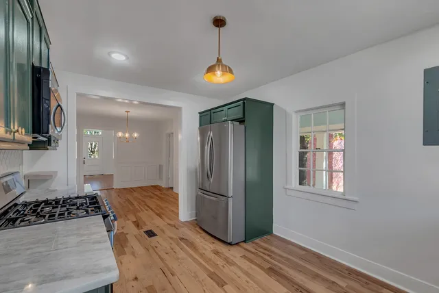 a kitchen with appliances a refrigerator and cabinets