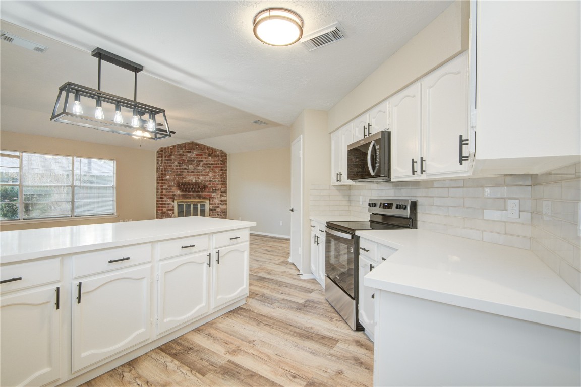 6722 Lynngate Drive Spring, TX 77373 - Photo 8 of 31 a large white kitchen with granite countertop a sink and dishwasher a stove top oven with white cabinets