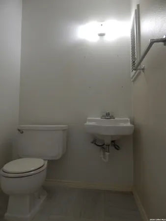 a bathroom with a toilet a sink and mirror